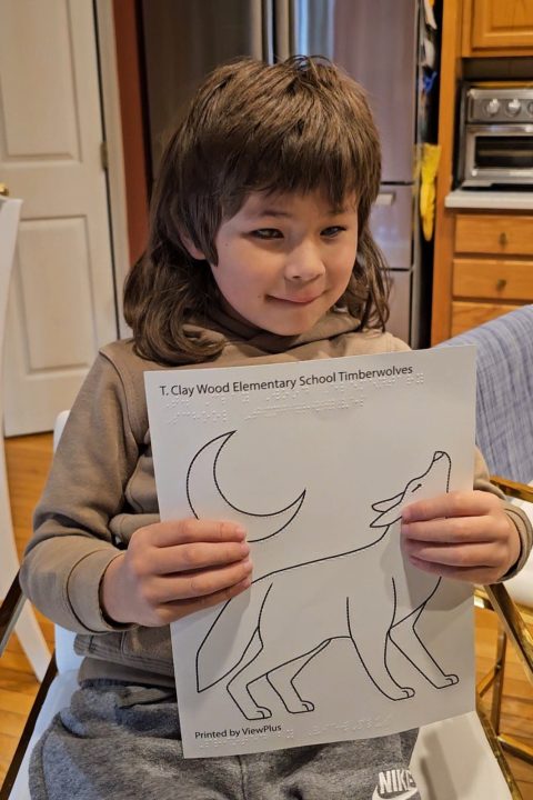 Photo of Jacoby holding a wolf coloring page